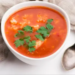 Aksamitna zupa pomidorowa z ryżem, udekorowana natką pietruszki. Ania gotuje, a efekt jest pyszny!