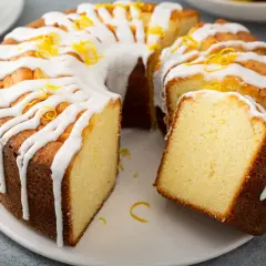 Szybka babka wilgotna, polana lukrem i posypana skórką cytrynową, kusi swoim apetycznym wyglądem.
