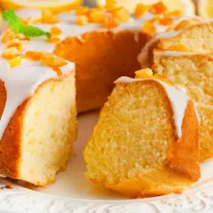 Puszysta babka wielkanocna cytrynowa, polana lukrem i posypana kandyzowaną skórką cytrynową, prezentuje się apetycznie.