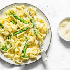 Pyszny makaron ze szparagami, polany kremowym sosem i posypany parmezanem. Idealny na wiosenny obiad.