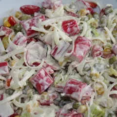 Pyszna sałatka z surimi, groszkiem, kukurydzą i porem, polana kremowym sosem.