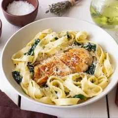 Pyszny makaron ze szpinakiem i kurczakiem, posypany parmezanem. Idealny obiad dla całej rodziny.