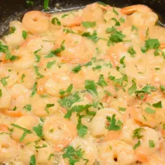 Soczyste krewetki z czosnkiem i natką pietruszki, duszone na patelni w maśle. Aromatyczne danie gotowe do podania.