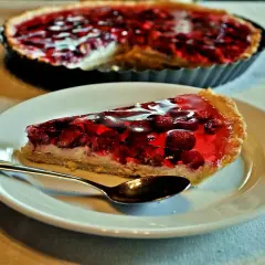 Pyszna tarta z mascarpone i owocami w galaretce, z łyżeczką gotową do degustacji.