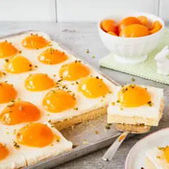 Ciasto jajko sadzone z brzoskwiniami i pistacjami, wygląda jak słodkie, wiosenne śniadanie.
