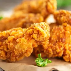 Chrupiące skrzydełka jak z KFC, złociste i apetyczne, podane na papierze.