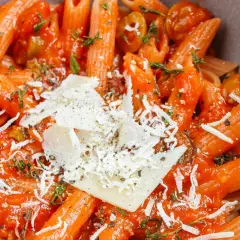Penne w sosie pomidorowym z oliwkami i parmezanem, aromatyczne dania z makaronem.