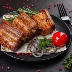 Soczyste żeberka w marynacie, podane z pomidorkiem i ziołami. Idealne na grilla!