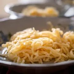 Talerz z delikatnym makaronem do rosołu, gotowym do podania.