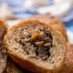 Kotlety mielone z pieczarkami, przekrojone na pół, ukazujące soczyste nadzienie.