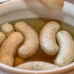 Biała kiełbasa w bulionie, gotowa do podania. Idealny przepis na tradycyjne danie.