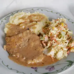 Pyszny schab w sosie podany z puree ziemniaczanym i chrupiącą surówką z kapusty i marchewki. Idealny obiad.