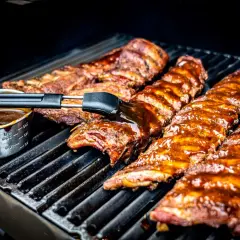 Pyszne żeberka z grilla pokryte sosem BBQ, pędzelkiem smarowane, kuszą apetycznym wyglądem.