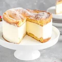 Puszysty kremowy tort, jeden z 10 najlepszych ciast, z ciastem ptysiowym i owocami w tle.