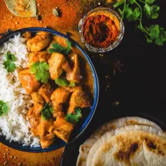 Aksamitny butter chicken przepis z ryżem i plackami naan. Aromatyczne przyprawy i świeża kolendra dopełniają danie.
