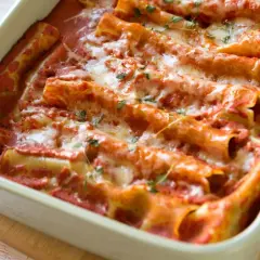 Pyszne cannelloni ze szpinakiem, zapieczone pod sosem pomidorowym i serem. Idealne na rodzinny obiad.