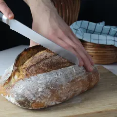 Krojenie świeżo upieczonego chleba na desce. Idealny przepis na chleb dla każdego.