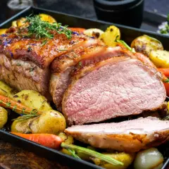 Soczysta polędwica wieprzowa z piekarnika, pieczona z ziemniakami, marchewką i cebulą. Aromatyczne zioła podkreślają smak dania.