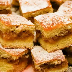 Pyszne ciasto z jabłkami, pokrojone w kostkę i posypane cukrem pudrem. Idealne na deser!