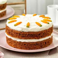 Dwupoziomowe ciasto marchewkowe z kremem mascarpone, ozdobione marcepanowymi marchewkami. Idealne na wiosenne przyjęcie.