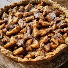 Apetyczna tarta na słodko z jabłkami i kruszonką, posypana cukrem pudrem. Idealna na deser.