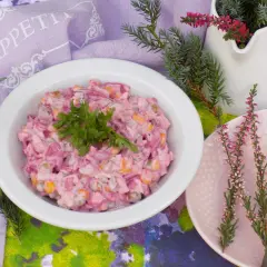 Pyszna sałatka z burakiem i jajkiem i ogórkiem kiszonym, udekorowana natką pietruszki, na stole z wrzosami.
