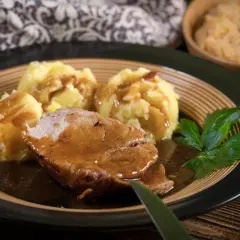 Mięciutka karkówka w sosie, podana z purée ziemniaczanym i surówką. Idealny obiad na chłodne dni.