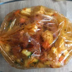 Karkówka pieczona w rękawie z warzywami, gotowa do pieczenia. Mięso i ziemniaki w przyprawach.