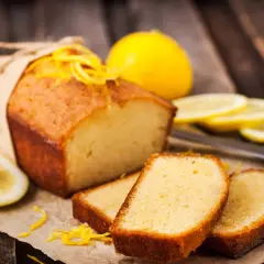 Babka piaskowa Ani Gotuje, pachnąca cytryną, z plasterkami owocu i skórką na drewnianym tle.