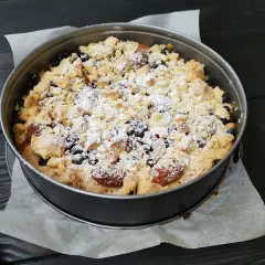 Pyszne kruche ciasto ze śliwkami i kruszonką, posypane cukrem pudrem, czeka na spróbowanie.