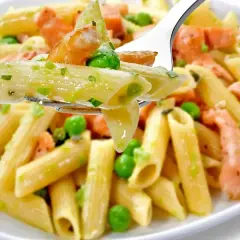 Penne z łososiem wędzonym i groszkiem na widelcu. Pyszne danie, które zachwyci każdego smakosza.