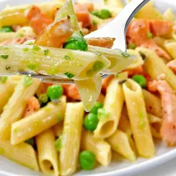 Penne z łososiem wędzonym i groszkiem na widelcu. Pyszne danie, które zachwyci każdego smakosza.