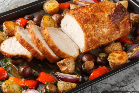 Pieczony schab z chrupiącą skórką, podany z ziemniakami, pieczarkami i papryką. Idealny na obiad, dzięki marynacie do schabu.