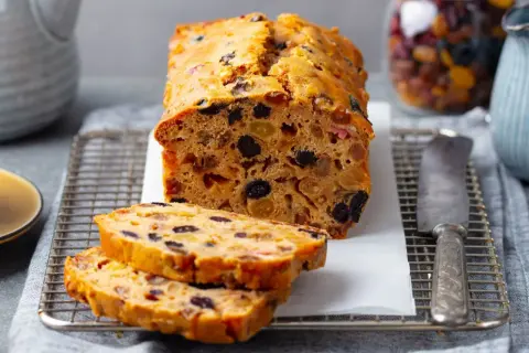 Pyszny keks Ani gotuje się w piekarniku, pełen bakalii. Pokrojone plastry kuszą aromatem.