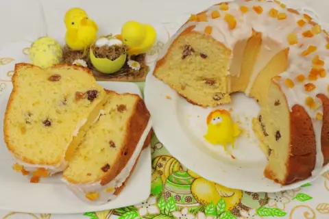 Pyszna, luksusowa babka drożdżowa z bakaliami, ozdobiona lukrem i kandyzowaną skórką. Idealna na Wielkanoc, jak sugerują urocze kurczaczki i pisanki.