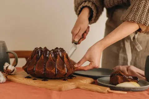 Babcia Ania gotuje pyszny, czekoladowy babko drożdżowe. Kroi pierwszy kawałek, by podzielić się nim z bliskimi.