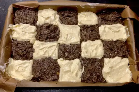 Seromakowiec Ani gotuje się w blaszce, tworząc szachownicę z ciemnego ciasta makowego i jasnego serowego.