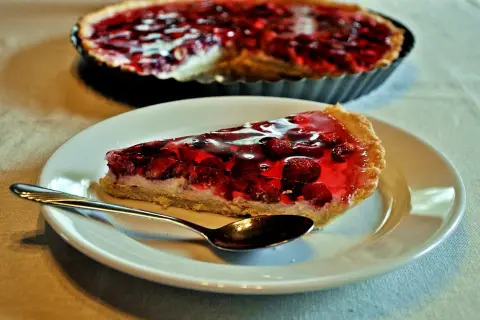 Pyszna tarta z mascarpone i owocami w galaretce, z łyżeczką gotową do degustacji.