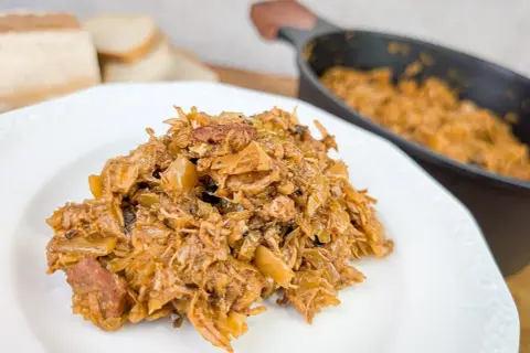 Pyszny bigos na talerzu, idealny do podania z chlebem. Dowiedz się, jak zrobić bigos, by zachwycić bliskich!