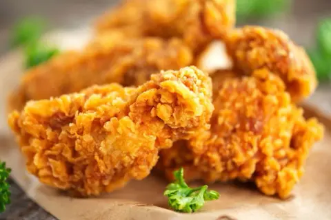 Chrupiące skrzydełka jak z KFC, złociste i apetyczne, podane na papierze.