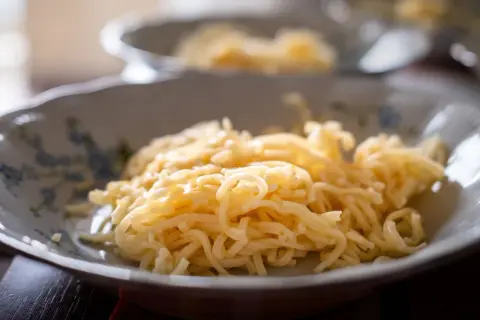 Talerz z delikatnym makaronem do rosołu, gotowym do podania.