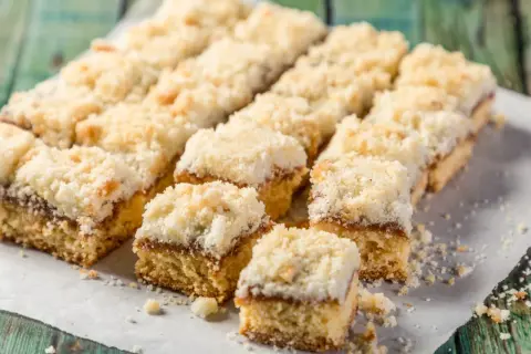 Szybkie ciasto na niedzielę do kawy, pokrojone w kostkę, z kruszonką i dżemem. Idealne na leniwe popołudnie.