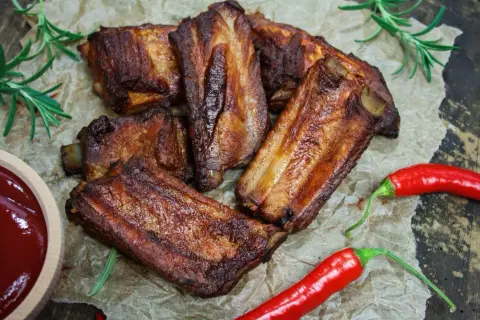 Soczyste żeberka w coli, pieczone do perfekcji, podane z sosem i papryczkami chili.