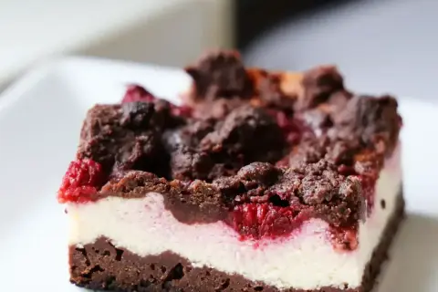 Pyszny sernikobrownie z malinami, z czekoladową kruszonką i kremowym serkiem. Idealny deser dla każdego łasucha.