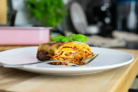 Pyszna lasagne na talerzu, idealna na jeden z 10 pomysłów na obiad. Złocisty ser i aromatyczny sos zachęcają do spróbowania.