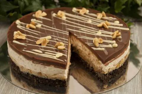Pyszne ciasto snickers bez pieczenia z czekoladą, orzeszkami i kremem. Idealne na deser.
