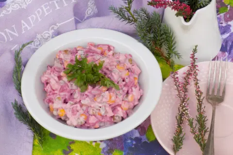 Pyszna sałatka z burakiem i jajkiem i ogórkiem kiszonym, udekorowana natką pietruszki, na stole z wrzosami.