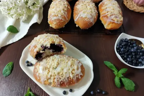 Prosty przepis na pyszne i pulchne jagodzianki z kruszonką i lukrem. Idealne na deser lub śniadanie.