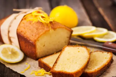 Babka piaskowa Ani Gotuje, pachnąca cytryną, z plasterkami owocu i skórką na drewnianym tle.