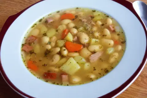 Pyszna zupa fasolowa przepis babci. Biała fasola, ziemniaki, marchewka i kawałki wędzonki w aromatycznym bulionie.